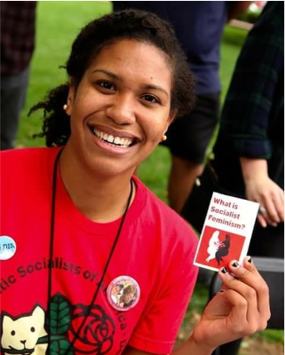 Woman holding leaflet entitled 'What is Socialist Feminism?'