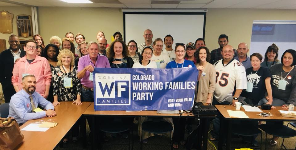 People gathered around a Colorado Working Families Party banner